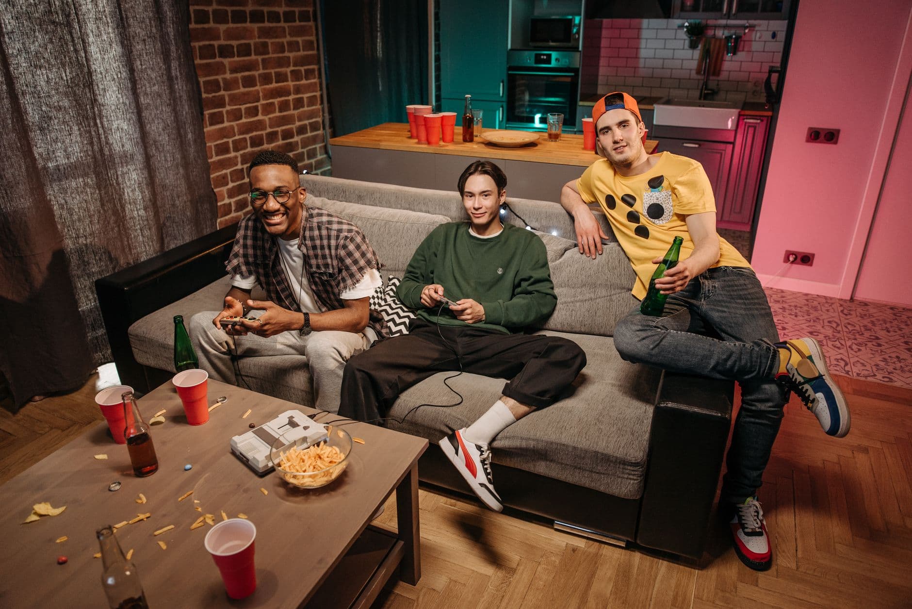 Three friends having fun playing video games together in a cozy living room setting.
