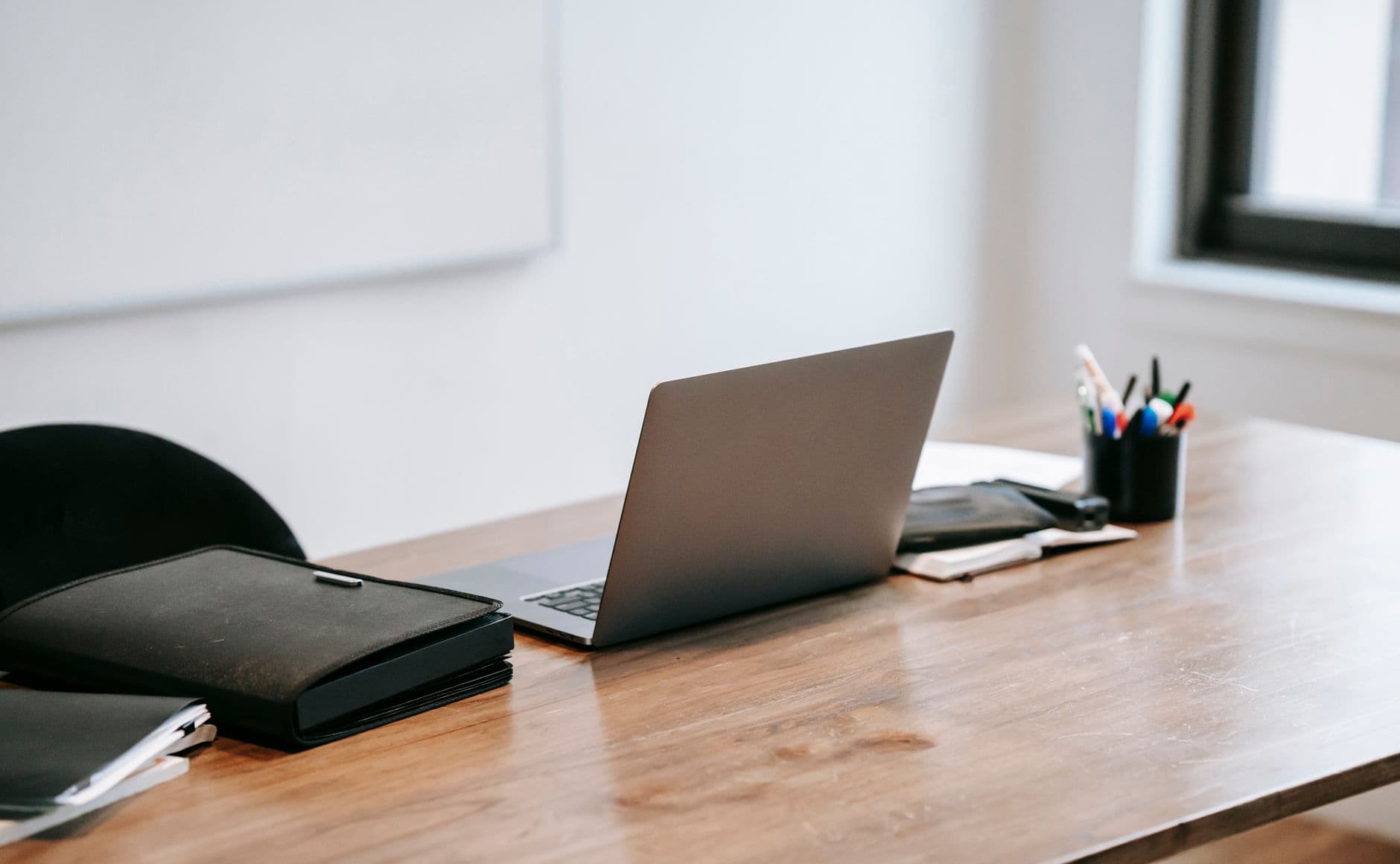A clean workspace featuring a modern laptop on a wooden desk, ideal for productivity.