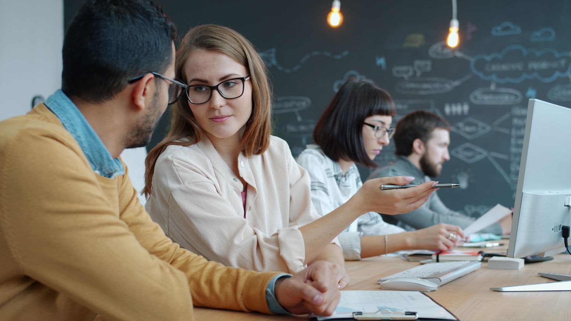 Group of young professionals collaborating in a creative modern workspace.
