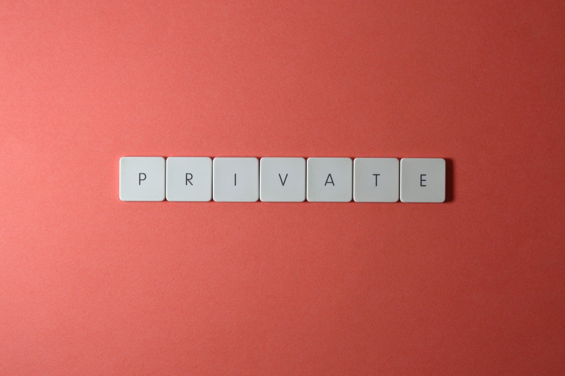White letter tiles spelling 'PRIVATE' on a red background, offering conceptual minimalist design.