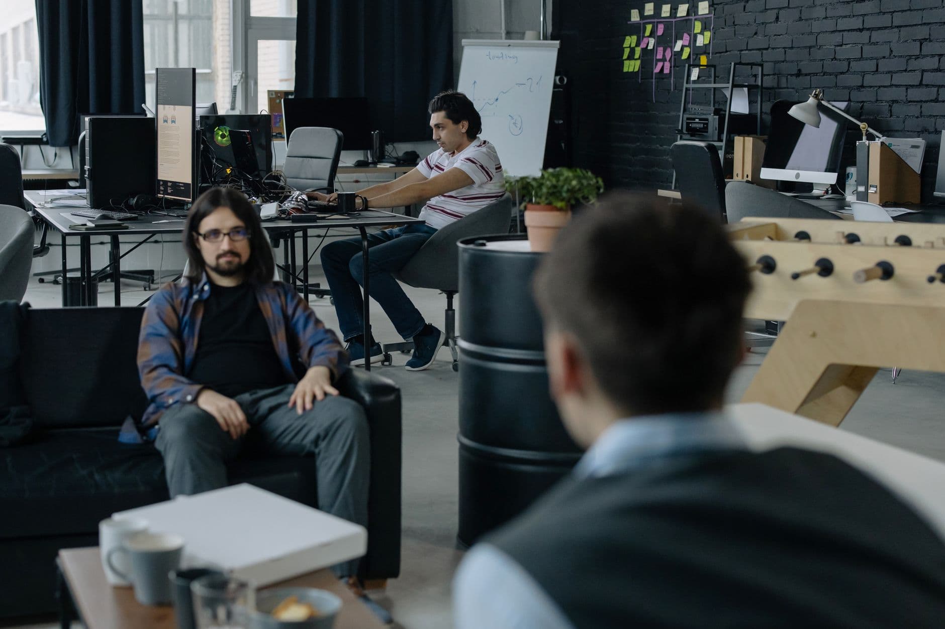 Team of professionals collaborating in a modern open office space with multiple workstations.