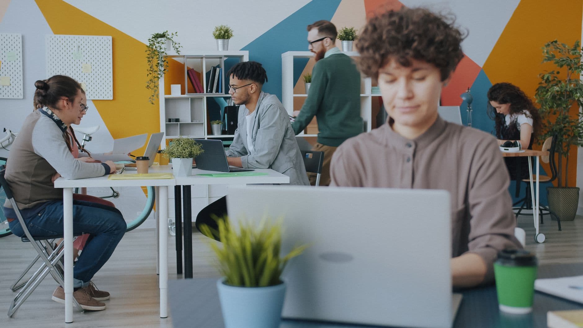 Creative workspace with diverse team collaborating on projects in a modern office setting.
