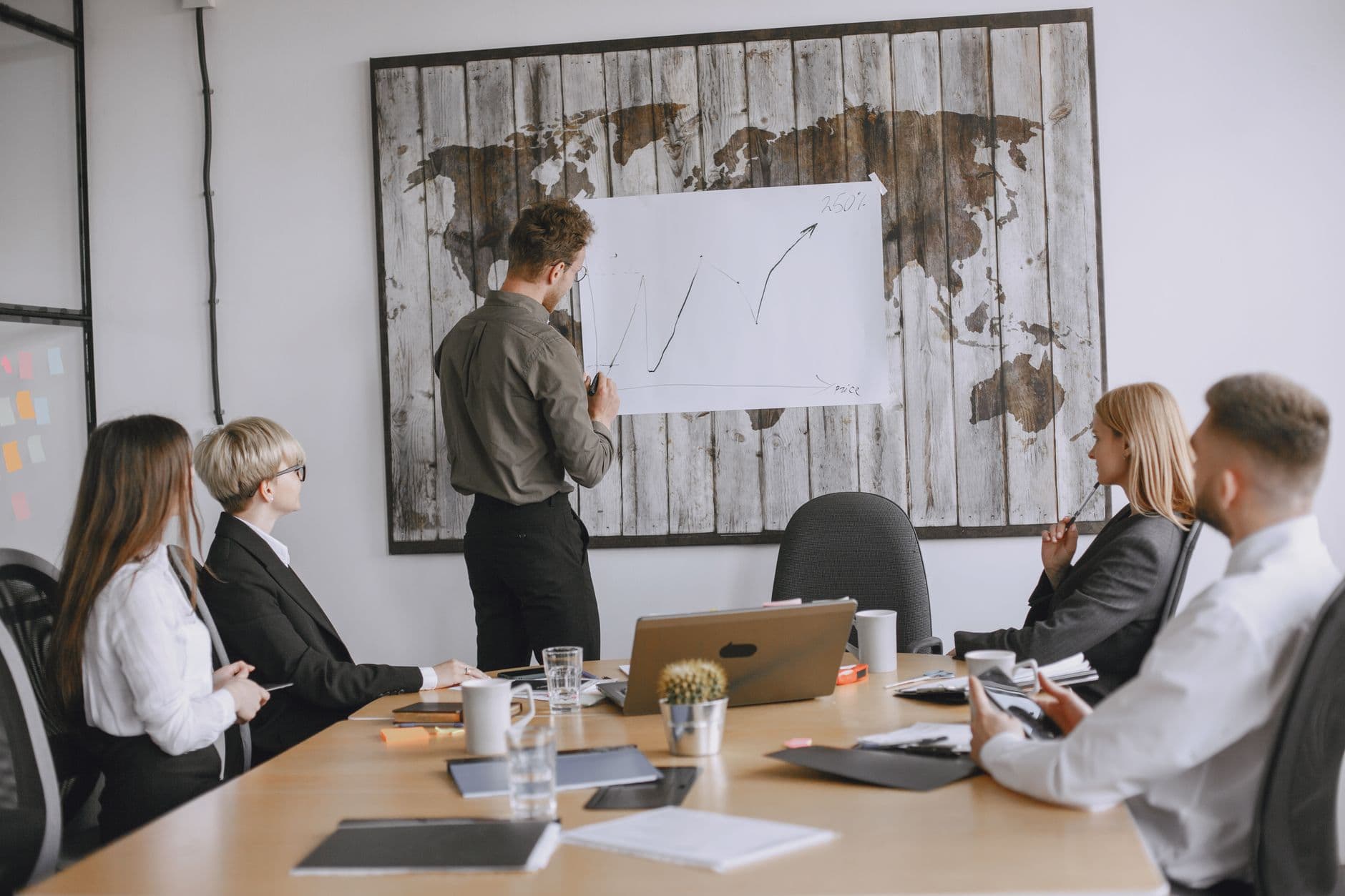 Group of business professionals discussing strategies with growth chart in conference room.