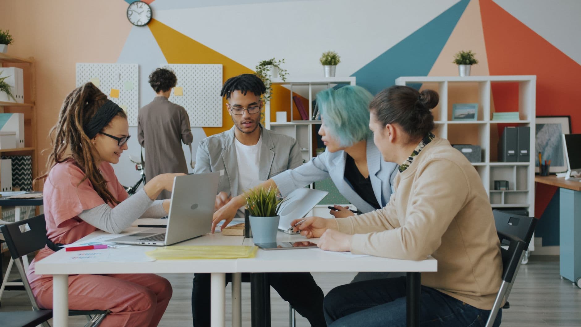 Diverse team engaged in a collaborative meeting in a modern office with vibrant decor.